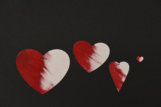 four hearts of wood painted with acrylic