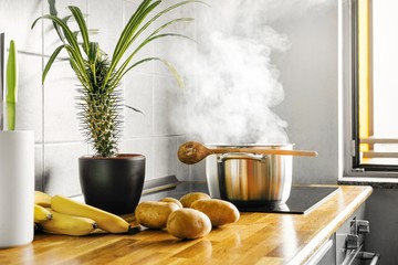 interior of kitchen with boiling pot on oven
