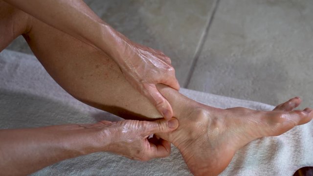 Extreme closeup of mature woman using her fist to massage the sole of her foot.