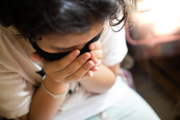 The child is ill with the flu and the corona virus is sneezing by closing the mouth to prevent the spread of the virus confined to the house.