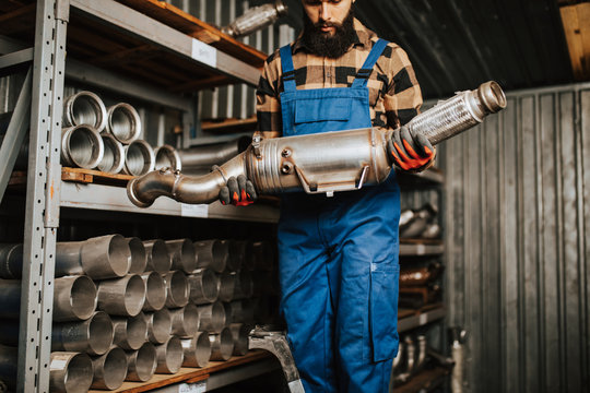 Handsome adult man working in car and truck spare parts warehouse.