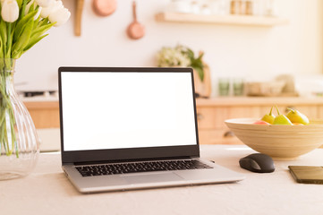 A workplace in a bright kitchen during quarantine. Laptop with place for text. Telework. freelance....