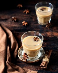 Masala tea in glass glasses on a dark wooden background. rustic  