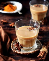 Masala tea in glass glasses on a dark wooden background. rustic  