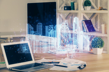 Desktop computer background in office and big town buildings hologram drawing. Double exposure. Smart city concept.