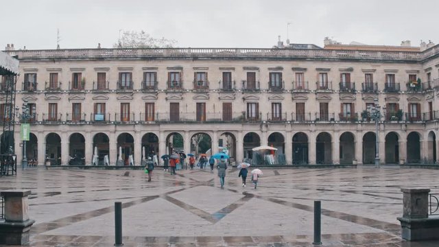 4K Plaza Nueva, Vitoria Gasteiz, people walking with umbrellas, town hall square