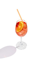 Aperol Spritz cocktail with a slice of orange, ice cubes and an orange straw is contained in a high...