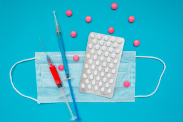 Medical mask, vaccine syringe and pink pills, pills blister. Economy crisis. Health expense....