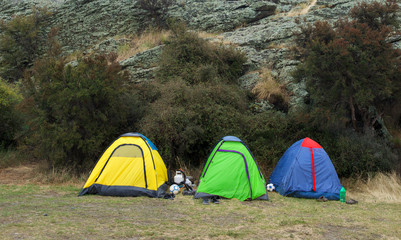 Tourists camped on a grass.Camping concept. Camping tents placedin the mountains.Tourist tent and equipment in the camp. Travel and Relax. Active lifestyle