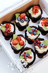 Bright cupcakes with strawberries and blueberries.