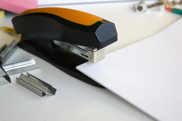Classic black office stapler with documents.