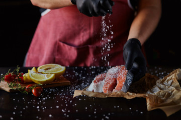 The chef prepares fresh salmon fish, white salt leaves with ingredients. Salmon steak, restaurants, hotel business, menu and recipe book