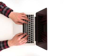 Fototapeta na wymiar Top view of man typing on modern laptop. Coffee in hand. 