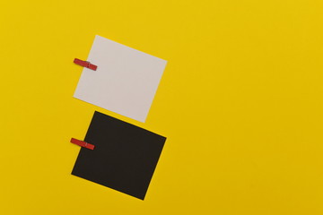 two sheets of black and white paper with clothespins