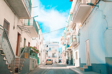 The narrow streets of the island with blue balconies, stairs and flowers.
