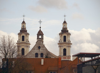 Fototapeta na wymiar Church crosses over red house roof in Europe