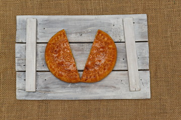 divided into two parts cabbage pie on burlap and wood