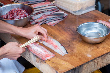 Japanese Chef sticking of eel and preparing for cooking. Chef prepare eel for grilling. Eel killing...