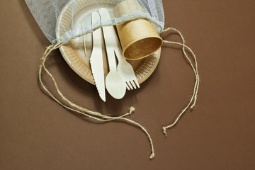 Zero waste, environmentally friendly, disposable, cardboard, paper utensils on a brown background. View from the top.