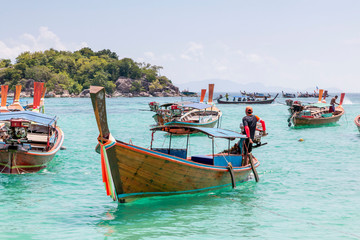 Thai traditional wooden long-tail boat and beautiful sand beach. Longtail boat on tropical island in Thailand. Tropical beach, longtail boats, Andaman Sea.