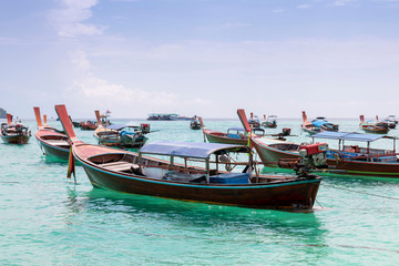 Fototapeta na wymiar Thai traditional wooden long-tail boat and beautiful sand beach. Longtail boat on tropical island in Thailand. Tropical beach, longtail boats, Andaman Sea.