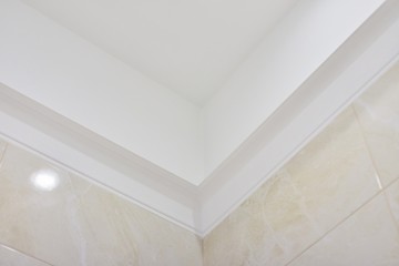 Bathroom, ceiling with moldings, beige tiles on the wall