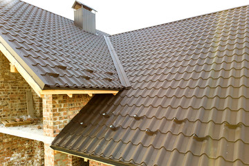 Close up of new house roof structure covered with metal tile sheets. © bilanol