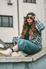 Image of a pleased happy cute young student curly girl sitting on bench outdoors