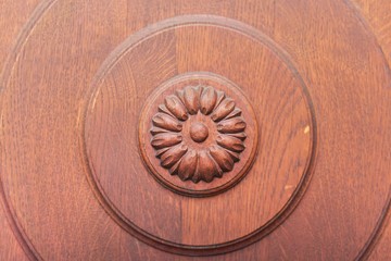 Detail of carved brown wooden door with ornament