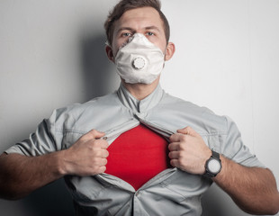 A superhero in a red t-shirt and a medical mask tears his shirt on his chest, rushing to help...