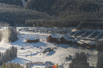 Aerial view of lodges or chalets at the Lake Louise ski area at the bottom on a sunny cold winter day.