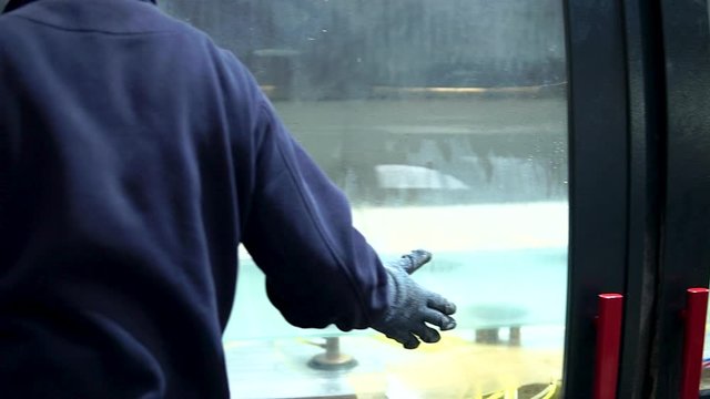 Glass factory employee closing cnc door, medium shot 