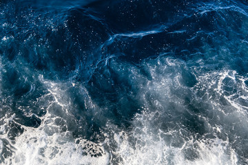 Obraz na płótnie Canvas Top down aerial view of sea water surface. White foam waves texture as natural background.