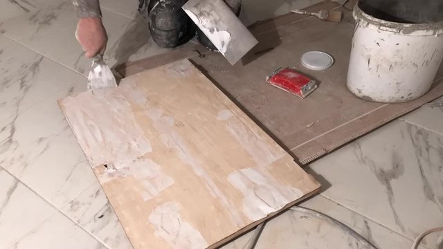 Time lapse of puttying white wood board with white wood filler  on marble floor