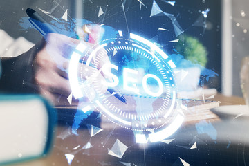 Multi exposure of woman's hands making notes with SEO icon. Concept of Search engine optimization