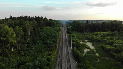 Aerial view: train at the rural scene in summer. The train rides through the rural countryside in the sunrise.