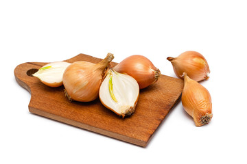 fresh bulbs of onion on a wooden cutting board on a white background