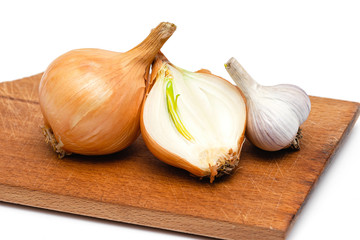 fresh bulbs of onion and garlic on a wooden cutting board on a white background