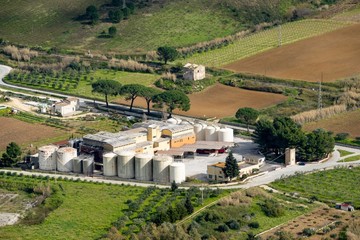 The agriculture and industry in the landscape of Sicily, Italy. The industrial building, tanks and...