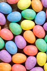 Easter background. Flat lay. Background from bright Easter eggs of different colors. Handmade painted eggs. Close-up, vertical, cropped shot. Easter concept.