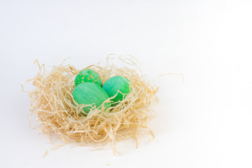 Happy Easter card. Colorful shiny eggs in a nest isolated on a white background. Copy space for text.
