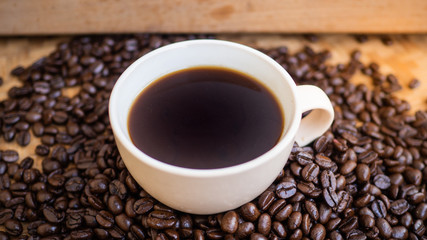 dark rose coffee bean, Black coffee cup on old wooden table top view.