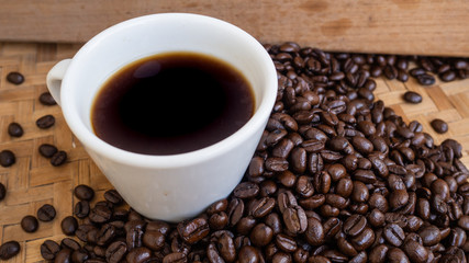 dark rose coffee bean, Black coffee cup on old wooden table top view.