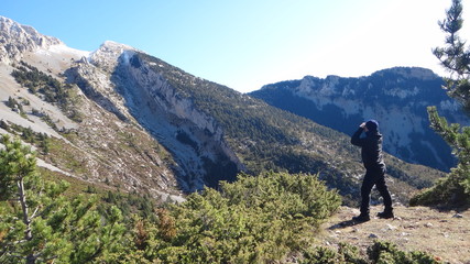 Naklejka premium Bosque en una montañas, la silueta del cielo, un hombre mirando y reflejo del sol