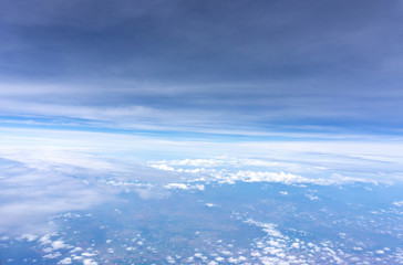 Naklejka na ściany i meble Skyscape view from clear glass window seat from aircraft to cloudscape, traveling on white fluffy clouds and vivid blue sky in a suny day