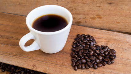 dark rose coffee bean, Black coffee cup on old wooden table top view.