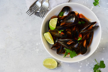 mussels in tomato sauce with lime and parsley. dish for lunch or dinner of seafood. selective focus, top view