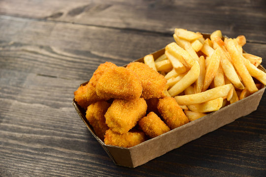 food delivery service. hot chicken nuggets and fries. take out food in a single use packaging made of recycled cardboard. takeaway food . selective focus and copy space