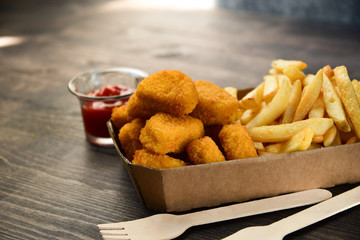 food delivery service. hot chicken nuggets and fries. take out food in a single use packaging made of recycled cardboard. takeaway food . selective focus and copy space