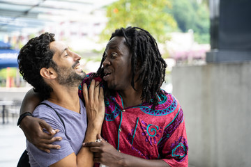 Gay couple of different ethnicities joking togethe